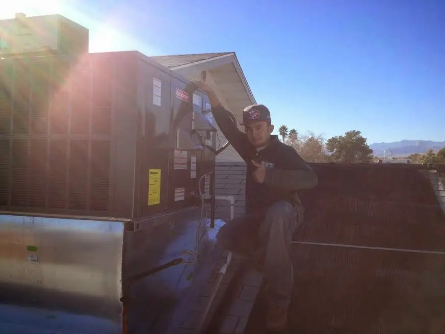 HVAC technician performing Heat Pump Repair on a rooftop unit in Philomath